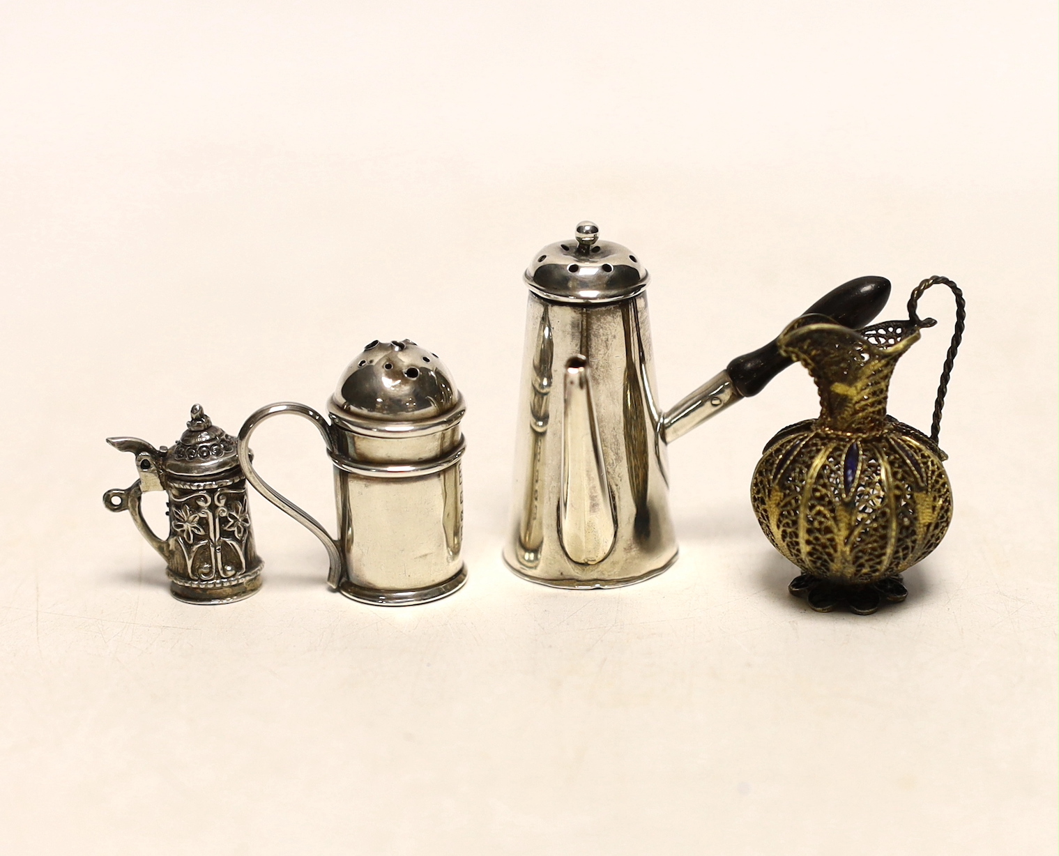 A late Victorian miniature silver chocolate pot, Saunders & Shepherd, Chester, 1894, 42mm, a miniature silver kitchen pepper, miniature tankard and filigree jug.